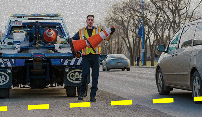 towtruck roadside worker with pylon